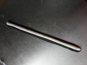 再取一个4克的黑色面团擀成长片包裹住刚才的面团，青蛙的一直眼睛就做好了，同样做好另一只眼睛用保鲜膜盖好。