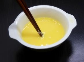 鸡蛋去壳，用筷子调均，加少许温水继续顺时针调均；