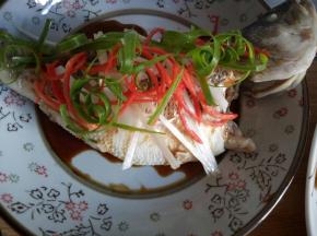 鱼身上铺葱丝、红椒丝。小葱取绿色部分撕开铺在鱼背上。