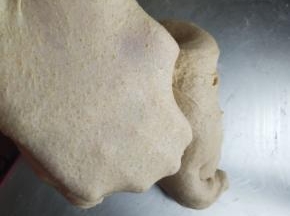 揉到面团撑出大片的膜加入黄油继续揉面成手套膜