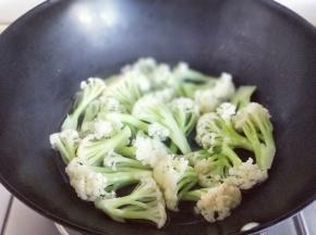 有机花菜焯水，水烧开后加入花菜，再次烧开捞出，过冷水，再捞出淋干水份。