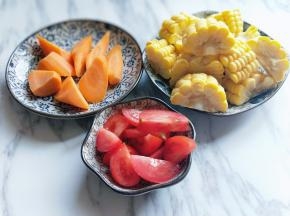 准备配料:胡萝卜去皮，切菱形块，玉米冷水冲洗，切段，番茄洗干净，切块备用。