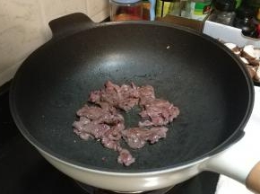 锅里下油放入牛肉片（市场买现成已腌好的）炒至焦熟捞起备用