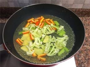 烧一锅开水，将花菜、土豆、莴苣、胡萝卜焯水一分钟，捞出沥干水份备用。
