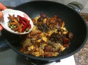 放入花椒、八角和干红辣椒翻炒10秒。