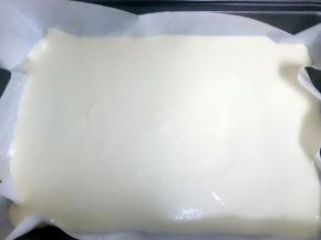 烤盘中垫上油纸，把蛋糊倒进去，拿起烤盘震几下，震去里面的气泡