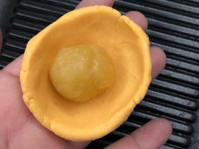 红薯皮涅成圆形包入绿豆沙馅料搓圆。