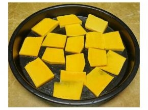 南瓜去皮后三分之一切成片，烤盘先抹一层牛油，南瓜片铺底 