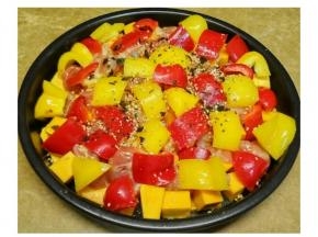 剩余南瓜、鸡腿肉、黄红椒切成大小一致的小块， 然后均匀的铺上鸡肉粒、南瓜粒、黄红椒，表面刷上一层橄榄油，再撒上一层蒜盐 