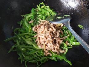 青椒变色，放入肉丝翻炒。