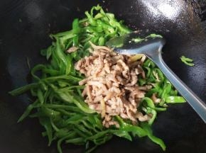 青椒变色，放入肉丝翻炒。