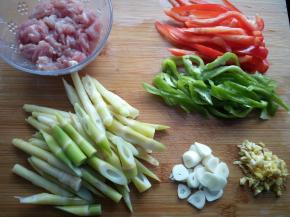 竹笋切斜刀，青、红辣椒切丝，肉切丝，蒜切片，姜切末。