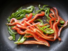 锅内留底油，放入青、红辣椒。