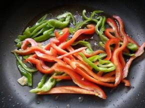 锅内留底油，放入青、红辣椒。