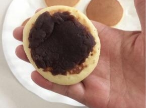 在做好的面饼上涂一层豆沙。