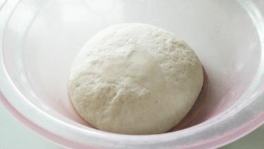 面团发酵一会，略微鼓起来，淋入1茶匙花生油在略微揉一揉。