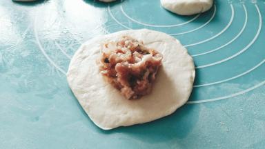 剂子按扁，中间放馅。