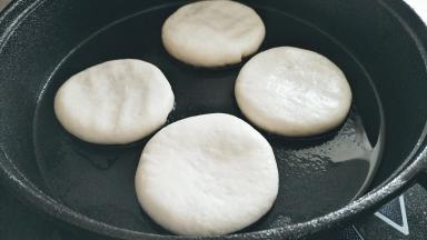 平底锅刷一层，直接放入包子按扁。