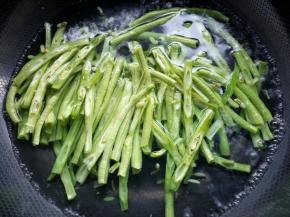 锅内烧开水，将豆角下入焯水一分钟捞起，放入凉水中过凉。