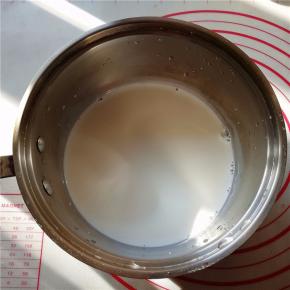 牛奶倒入奶锅中，加热至80度，然后晾凉至温热（30度)。