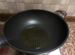 热锅倒油烧至八成热。