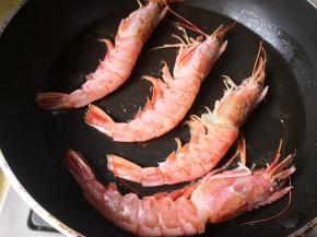 5.	平底锅里放入适量的油，油5成热时把大虾放进去，中小火煎，
