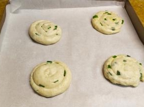 依次卷好，用手压扁一下，放入不粘锅盖上盖子醒发