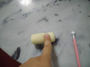 然后图中的位置，也就是接近压洞口的那一头，用手指搓细。