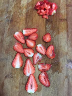 草莓清洗干净后，把中间的部分切成薄片，边角料切成小丁儿备用。