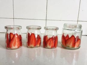 把切好的草莓片贴在提前清洗干净的布丁玻璃瓶中。