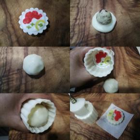 将如意坊月饼模具和花片洗净晾干，取一点点彩色面团将花片凹陷处填上，然后把花片装入模具，再取原色面团包入蔓越莓奶黄馅（面团与馅料的比例为1：1，如果为50g模具，则面团与馅料都是各取25g，我用的是65g模具，所以面团与馅料各取了32g），包好后放入模具，垂直向下轻压到底，拎起模具推出即可，一个美美的冰皮月饼就做好啦～