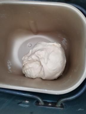 将除黄油，以外的所有材料放入面包机桶内，先转动按钮至和面程序，时间设置17分钟，当揉面剩余时间为10分钟的时候放入黄油，程序结束时检查面团，揉至扩展阶段