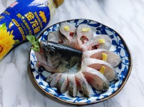 将鱼头摆放在盘子中间，再把鱼身体弯曲放入盘中，在每片鲈鱼肉上摆放切好的姜片。