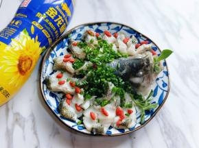 蒸熟的鱼取出，蒸出来的鱼大家都知道，会有很多汤汁，我们把汤汁小心的倒出，再撒上葱花，枸杞。