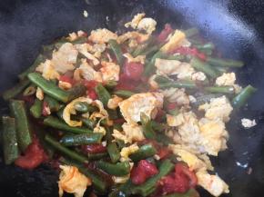 四季豆一共煸炒焖煮了10分钟后就软软的啦，这时候放入炒好的鸡蛋，翻炒均匀。