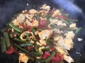 四季豆一共煸炒焖煮了10分钟后就软软的啦，这时候放入炒好的鸡蛋，翻炒均匀。