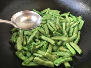 倒入40g左右的清水，立即盖上锅盖儿，这时锅里的水气循环，四季豆容易被煸熟些，特别注意的是四季豆不能生食，必须煮熟了才能吃，不然会中毒。