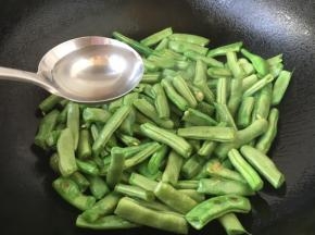 倒入40g左右的清水，立即盖上锅盖儿，这时锅里的水气循环，四季豆容易被煸熟些，特别注意的是四季豆不能生食，必须煮熟了才能吃，不然会中毒。