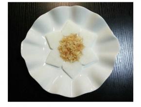 将心形萝卜摆在盘里，中间放上撕好的干贝。