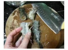 切开蝦頭，再一次切开虾肚子，但不要切断，切到虾皮就可以了，抽出虾线！ 