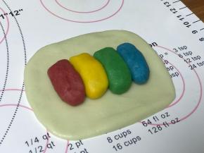 取水油皮面团，擀成小长方形，放4个油酥，颜色随意摆放