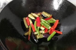 酱汁烧开后，倒入茄条和辣椒条快速翻炒几下，最后调入少许鸡精翻炒均匀即可起锅。