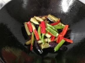 酱汁烧开后，倒入茄条和辣椒条快速翻炒几下，最后调入少许鸡精翻炒均匀即可起锅。