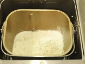 将除黄油外的所有面包材料按先液体后粉类的顺序放入面包机桶内