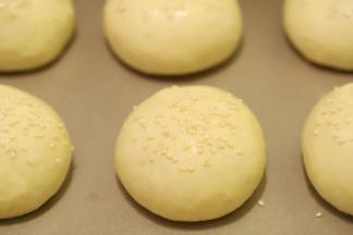 取出面包胚，表面刷上一层蛋黄液，撒少许白芝麻