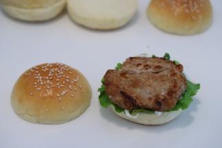 猪扒用刀背轻敲，放入黑椒酱、盐、料酒等配料腌制2小时以上，将腌制好的猪扒煎至双面金黄出锅。按自己喜好摆放好汉堡夹陷