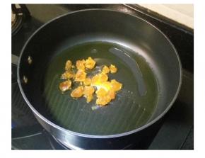 鍋里熱油，放入蛋黃碎。