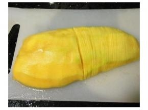 芒果去皮，放入盐水浸泡十分钟后如图切开再切薄片