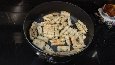 饼剪成条，青瓜切条备用。
锅里放少许油，油烧热后倒入饼条，放入蒜盐和孜然粉炒香