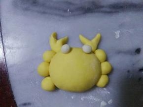 大圆两侧抹上点点水，两边平均沾上小圆和蟹钳。